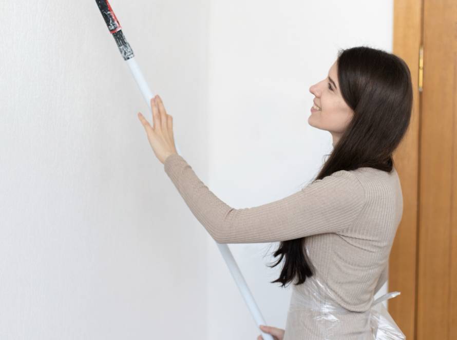 Painter rolling fresh paint on an interior wall