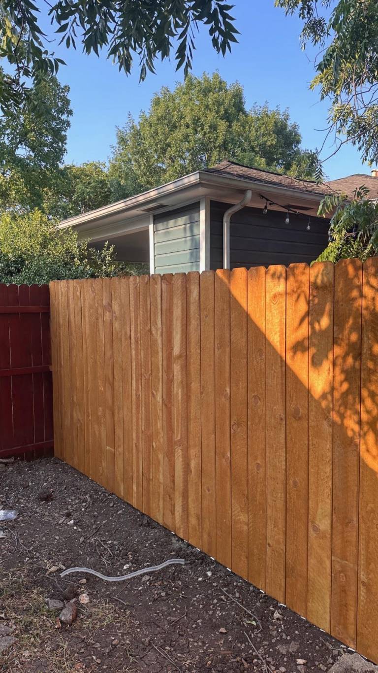Cedar fence next to a painted house