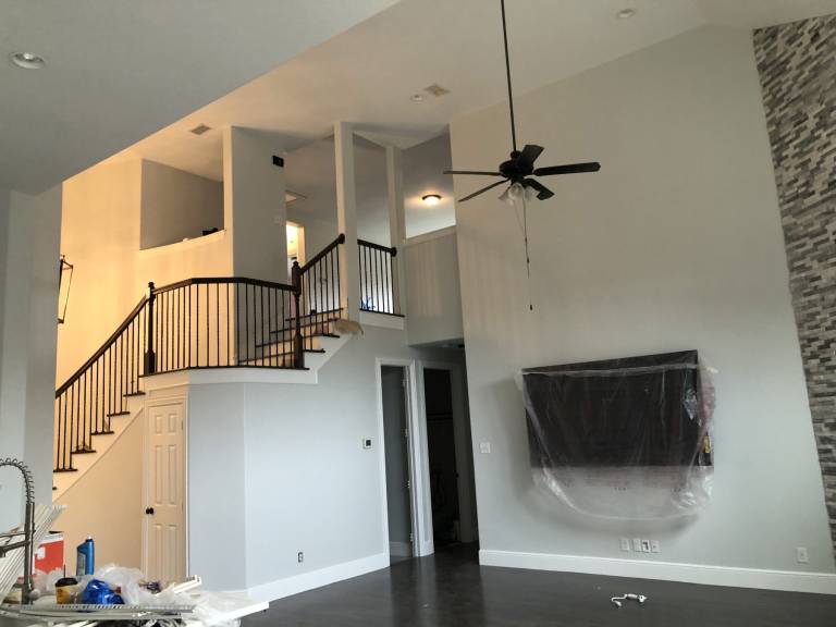Two-story living room with freshly painted walls and staircase
