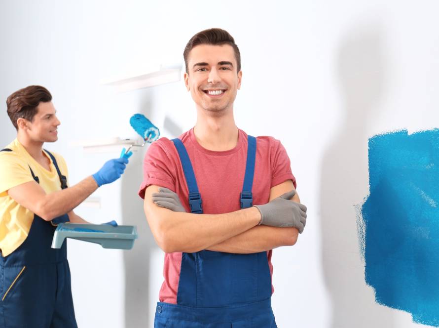 Professional painters painting a wall together