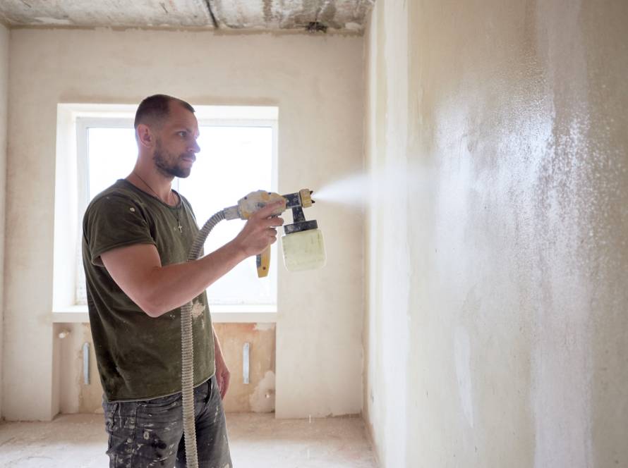 Painter spraying wall texture to match existing finish