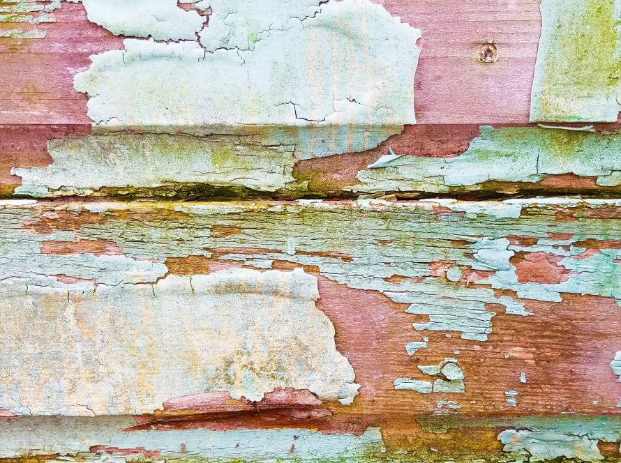 Weathered, peeling paint on wood siding